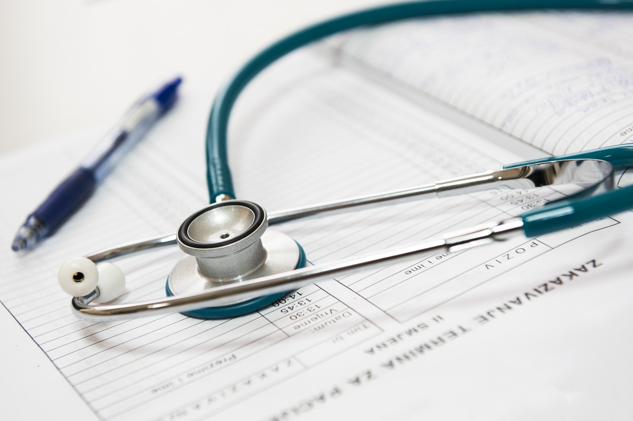 Stethoscope resting on private health insurance documents